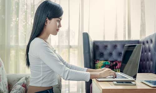 girl sitting up straight at office desk space with computer
